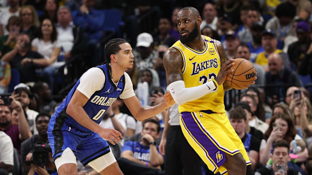 Los Angeles forward LeBron James (23) is guarded by Orlando guard Anthony Black.