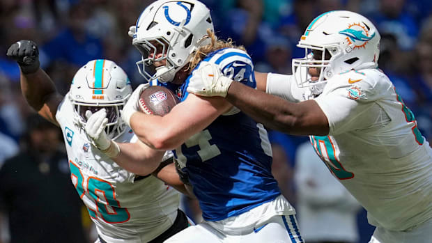 Colts tight end Tyler Warren (blue and white jersey) runs through contact.