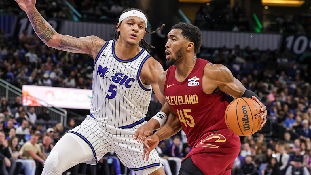 Jan 24, 2026; Orlando, Florida, USA; Cleveland Cavaliers guard Donovan Mitchell (45) drives around Orlando Magic forward Paolo Banchero (5) during the second half at Kia Center. Mandatory Credit: Mike Watters-Imagn Images
