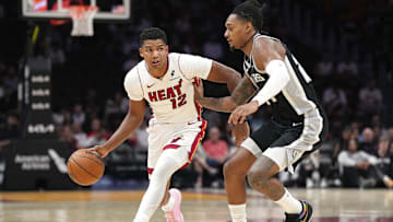 Oct 8, 2025; Miami, Florida, USA;  Miami Heat guard Dru Smith (12) drives up the court as San Antonio Spurs guard Devin Vassell (24) defends in the first half at Kaseya Center. Mandatory Credit: Jim Rassol-Imagn Images