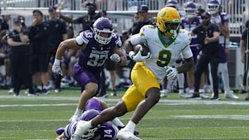 Sep 13, 2025; Evanston, Illinois, USA; Northwestern Wildcats linebacker Yanni Karlaftis (14) tries to tackle Oregon Ducks tight end Jamari Johnson (9) during the second half at Northwestern Medicine Field at Martin Stadium. Mandatory Credit: David Banks-Imagn Images
