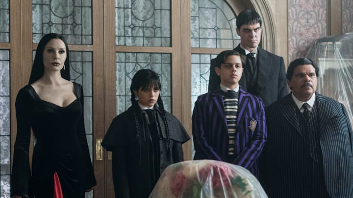 (L to R) Steve Buscemi as Barry Dort, Catherine Zeta-Jones as Morticia Addams, Jenna Ortega as Wednesday Addams, Isaac Ordonez as Pugsley Addams, Joonas Suotamo as Lurch, Luis Guzmán as Gomez Addams in episode 201 of Wednesday
