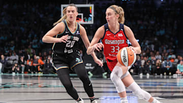 Sep 9, 2025; Brooklyn, New York, USA;  Washington Mystics guard Lucy Olsen (33) looks to drive past New York Liberty guard Sabrina Ionescu (20) in the first quarter at Barclays Center. Mandatory Credit: Wendell Cruz-Imagn Images