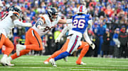 Jan 12, 2025; Orchard Park, New York, USA; Buffalo Bills running back Ty Johnson (26) runs for a gain as Denver Broncos defensive end Zach Allen (99) tackles during the fourth quarter in an AFC wild card game at Highmark Stadium. 