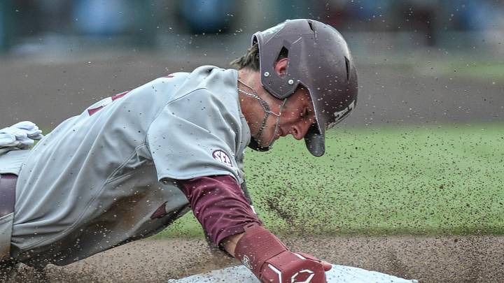 Jun 24, 2024; Omaha, NE, USA;  Texas A&M Aggies center fielder Travis Chestnut (4) steals third base against the Tennessee Volunteers during the third inning at Charles Schwab Field Omaha. Mandatory Credit: Steven Branscombe-Imagn Images