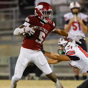 Raines High School running back Tadarius Washington (5) sheds Bishop Kenny Austin Green (8) in the second quarter. Raines High School hosted Bishop Kenny in the Class 3A high school football playoffs at Raines High School Friday night, November 28, 2025 in Jacksonville, Fla. Raines defeated Bishop Kenny 61-15. [Doug Engle/Florida Times-Union]