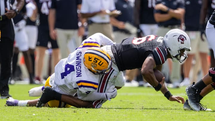 Sep 14, 2024; Columbia, South Carolina, USA; LSU Tigers defensive end Bradyn Swinson (4) sacks South Carolina Gamecocks quarterback LaNorris Sellers (16) during the second quarter at Williams-Brice Stadium. Mandatory Credit: Scott Kinser-Imagn Images