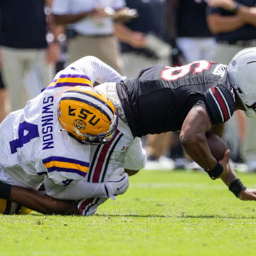 Sep 14, 2024; Columbia, South Carolina, USA; LSU Tigers defensive end Bradyn Swinson (4) sacks South Carolina Gamecocks quarterback LaNorris Sellers (16) during the second quarter at Williams-Brice Stadium. Mandatory Credit: Scott Kinser-Imagn Images
