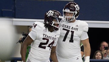 Sep 30, 2023; Arlington, Texas, USA; Texas A&M Aggies running back Earnest Crownover (24) and offensive lineman Chase Bisontis (71) celebrate after Crownover scores a touchdown against the Arkansas Razorbacks during the first half at AT&T Stadium. Mandatory Credit: Jerome Miron-Imagn Images