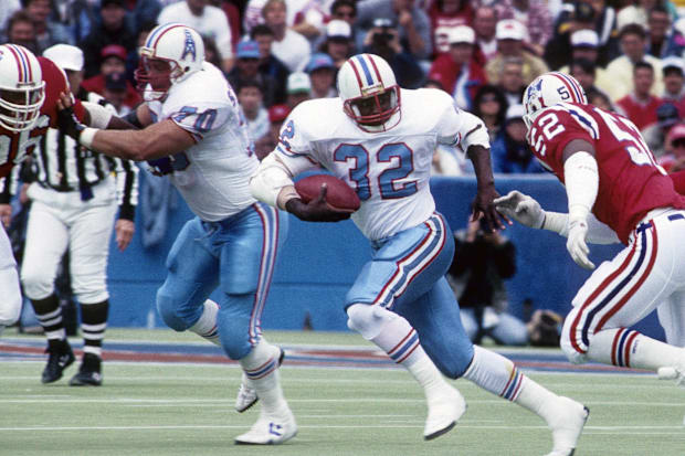 Houston Oilers running back Alonzo Highsmith (32) carries the ball past the block of Dean Steinkuhler (70).