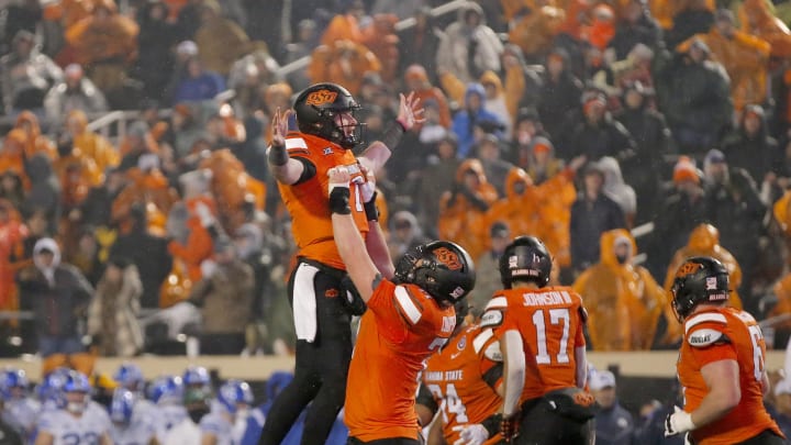 Nov 25, 2023; Stillwater, Oklahoma, USA;  Oklahoma State's Alan Bowman (7) celebrates with Dalton Cooper (71) following a touchdown during second half against the Brigham Young Cougars at Boone Pickens Stadium. Mandatory Credit: Sarah Phipps-USA TODAY Sports