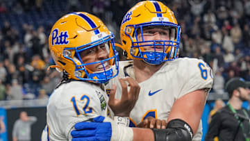Pittsburgh Panthers quarterback Julian Dugger (12) is helped off the ground by Pittsburgh Panthers offensive lineman Ryan Jacoby (61) after his touchdown came under review with Toledo Rockets believing they stopped him during one of the six overtimes at the 2024 GameAbove Sports Bowl at Ford Field in Detroit, Thursday, Dec. 26, 2024.