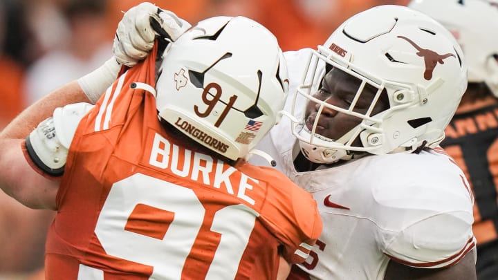 April 20, 2024; Austin, Texas, USA: Texas White team offensive lineman Cameron Williams (56) grabs the uniform of Texas Orange team edge Ethan Burke (91) in the second quarter of the Longhorns' spring Orange and White game at Darrell K Royal Texas Memorial Stadium. Mandatory Credit: Sara Diggins-USA Today Sports via American Statesman