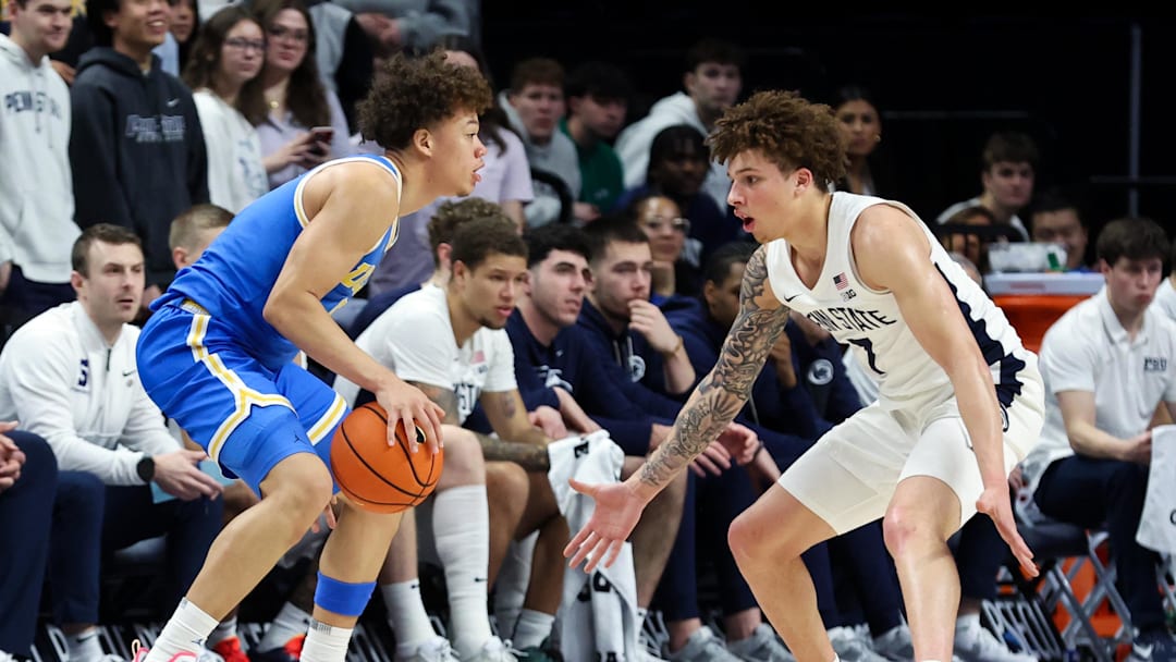 Jan 14, 2026; University Park, Pennsylvania, USA; UCLA Bruins guard Trent Perry (0) dribbles the ball as Penn State Nittany Lions guard Dominick Stewart (7) defends during the first half at Bryce Jordan Center. Mandatory Credit: Matthew O'Haren-Imagn Images