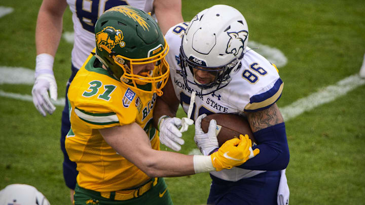 Jan 8, 2022; Frisco, TX, USA; Montana State Bobcats wide receiver Lance McCutcheon (86) is tackled by North Dakota State Bison linebacker Cole Wisniewski (31) during the first half of the FCS Championship at Toyota Stadium. Mandatory Credit: Jerome Miron-Imagn Images