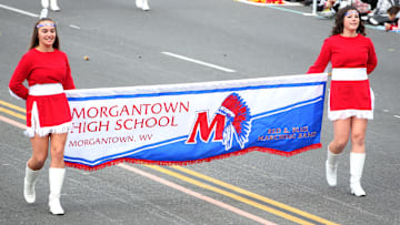 A pair of Morgantown High School students hold a banner during the band's performance at the 124th Rose Parade Presented By Honda. Daughters of WVU basketball coaches Darian DeVries and Mark Kellogg currently star for the Morgantown High School girls' basketball team.