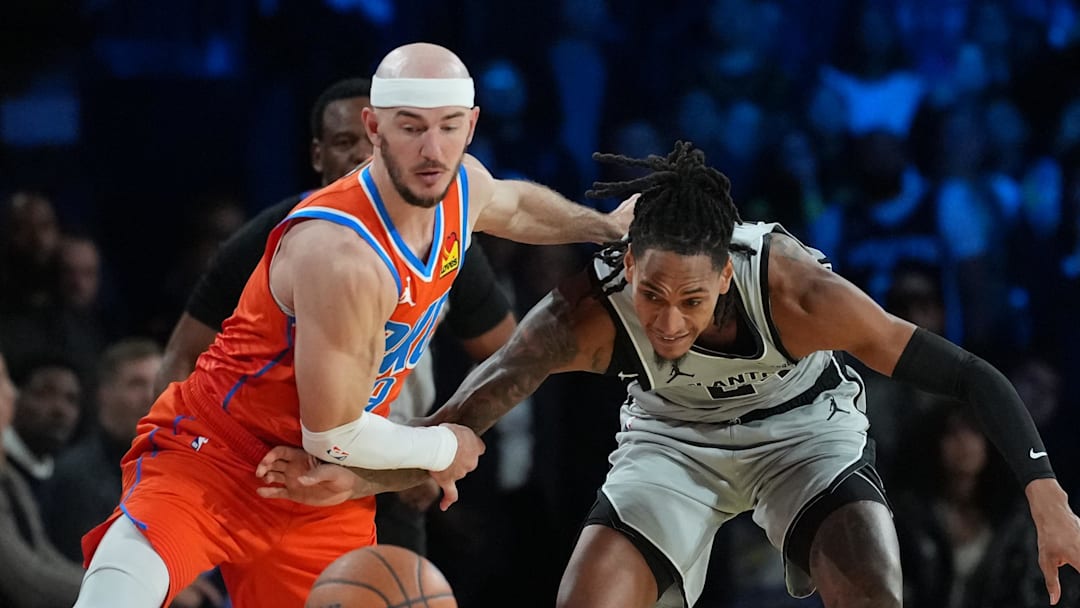 Dec 13, 2025; Las Vegas, Nevada, USA; Oklahoma City Thunder guard Alex Caruso (9) and San Antonio Spurs guard Devin Vassell (24) battle for the lose ball during the fourth quarter at T-Mobile Arena. Mandatory Credit: Kirby Lee-Imagn Images
