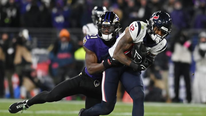 Jan 20, 2024; Baltimore, MD, USA; Houston Texans wide receiver Nico Collins (12) runs the ball against Baltimore Ravens cornerback Brandon Stephens (21) during the second quarter of a 2024 AFC divisional round game at M&T Bank Stadium. Mandatory Credit: Tommy Gilligan-USA TODAY Sports