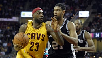 Nov 19, 2014; Cleveland, OH, USA; Cleveland Cavaliers forward LeBron James (23) drives against San Antonio Spurs forward Tim Duncan (21) and forward Kawhi Leonard (2) in the second quarter at Quicken Loans Arena. Mandatory Credit: David Richard-Imagn Images