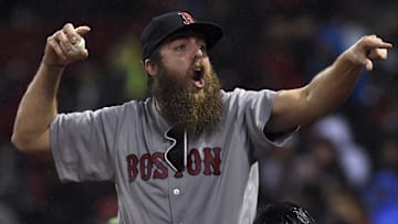 A fan reacts after getting a ball during the sixth inning in a game against the Boston Red Sox and Seattle Mariners at Fenway Park.