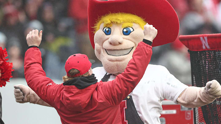 The Nebraska Cornhuskers mascot celebrates with a fan after a play during the first half against the Boston College Eagles