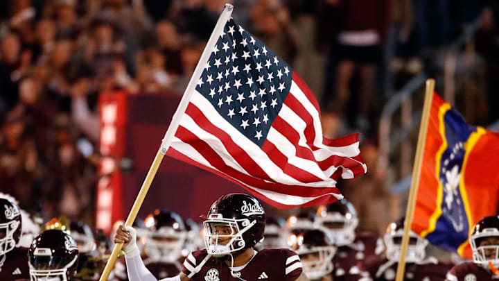 Mississippi State Bulldogs linebacker Nathaniel Watson carries an American Flag onto the field prior to the game against the Mississippi Rebels at Davis Wade Stadium at Scott Field.