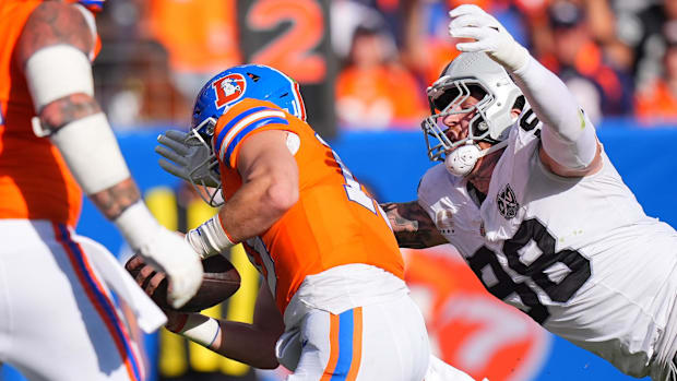 Las Vegas Raiders defensive end Maxx Crosby (98) leaps at Denver Broncos quarterback Bo Nix (10) for a sack.