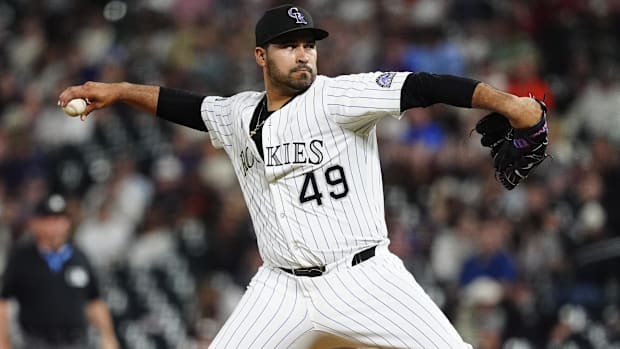 Antonio Senzatela pitching for the Colorado Rockies in white pinstripe uniforms. 