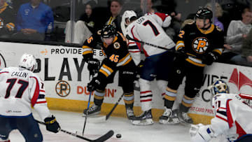 Providence Bruins center Fraser Minten and forward Fabian Lysell fighting for possession against Thundrbird Leo Loofin the second period.