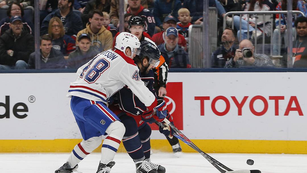 Nov 17, 2025; Columbus, Ohio, USA; Columbus Blue Jackets center Zach Aston-Reese (27) carries the puck as Montreal Canadiens defenseman Lane Hutson (48) defends during the second period at Nationwide Arena. Mandatory Credit: Russell LaBounty-Imagn Images
