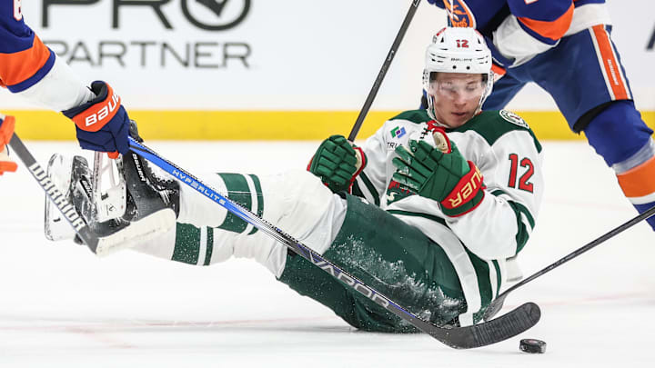 Apr 4, 2025; Elmont, New York, USA;  Minnesota Wild left wing Matt Boldy (12) chases the puck after falling down in the third period against the New York Islanders at UBS Arena. Mandatory Credit: Wendell Cruz-Imagn Images