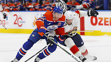 Florida Panthers defensemen Dmitry Kulikov (7) tries to tie up Edmonton Oilers forward Connor McDavid (97)