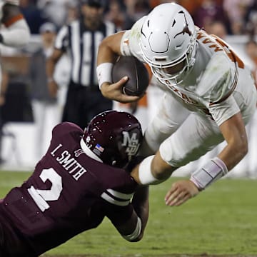 Oct 25, 2025; Starkville, Mississippi, USA; Texas Longhorns quarterback Arch Manning (16) runs the ball as Mississippi State Bulldogs defensive back Isaac Smith (2) makes the tackle during overtime at Davis Wade Stadium at Scott Field. Mandatory Credit: Petre Thomas-Imagn Images