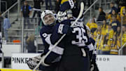 Penn State goalie Arsenii Sergeev (35) celebrates with teammate Casey Aman (3) after a Big Ten Tournament game against the Michigan Wolverines at Yost Ice Arena.