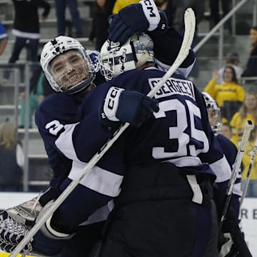 Penn State goalie Arsenii Sergeev (35) celebrates with teammate Casey Aman (3) after a Big Ten Tournament game against the Michigan Wolverines at Yost Ice Arena.