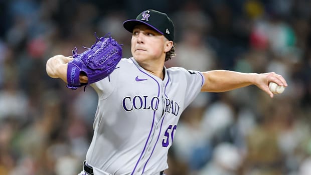 Colorado Rockies relief pitcher Ryan Rolison throws a baseball in a gray uniform and blackl hat