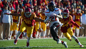 Nov 22, 2014; Ames, IA, USA; Texas Tech Red Raiders running back DeAndre Washington (21) escapes Iowa State Cyclones linebacker Brian Mills (25) and defensive back Nigel Tribune (34) at Jack Trice Stadium. Mandatory Credit: Steven Branscombe-Imagn Images