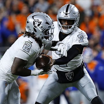 Nov 6, 2025; Denver, Colorado, USA; Las Vegas Raiders quarterback Geno Smith (7) hands the ball to running back Ashton Jeanty (2) during the first half at Empower Field at Mile High. Mandatory Credit: Isaiah J. Downing-Imagn Images