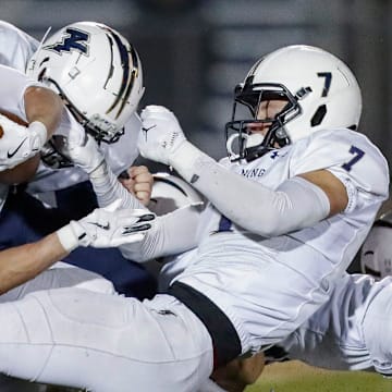 Appleton North High School's Ben Wenzel (7) tackles Bay Port High School's Tommy Kemen (3) during a WIAA Division 1 first round playoff game on Friday, October 24, 2025, at Bay Port High School in Suamico, Wis. Bay Port won the game, 41-6.