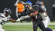 Dec 7, 2025; Atlanta, Georgia, USA; Atlanta Falcons running back Bijan Robinson (7) runs against Seattle Seahawks cornerback Devon Witherspoon (21) and linebacker DeMarcus Lawrence (0) during the first quarter at Mercedes-Benz Stadium. Mandatory Credit: Dale Zanine-Imagn Images