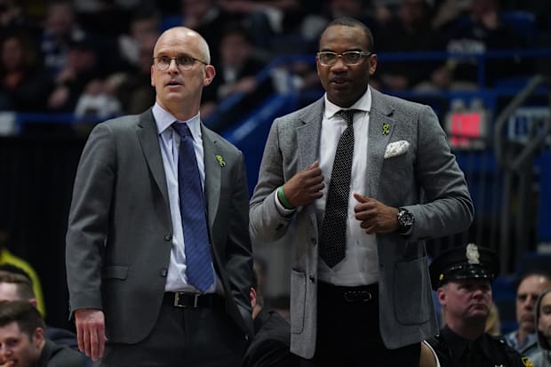 UConn head coach Dan Hurley and assistant coach Kimani Young watch from the sideline.