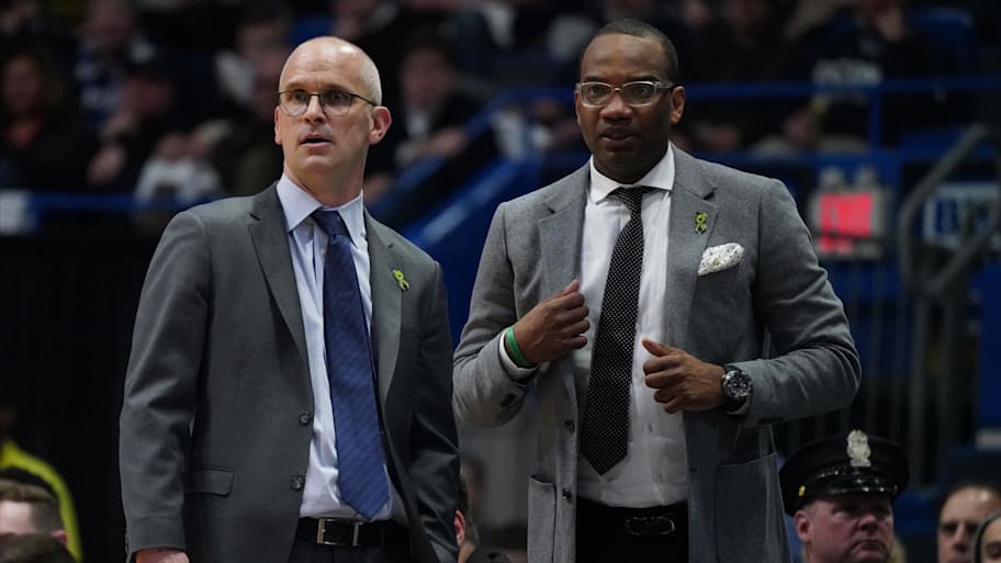 UConn head coach Dan Hurley and assistant coach Kimani Young watch from the sideline.