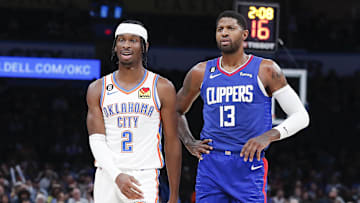 Oct 27, 2022; Oklahoma City, Oklahoma, USA; Oklahoma City Thunder guard Shai Gilgeous-Alexander (2) and LA Clippers guard Paul George (13) walks down the court during a time out during the first half at Paycom Center. Mandatory Credit: Alonzo Adams-Imagn Images
