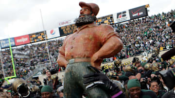 Michigan State players hold up the Paul Bunyan Trophy and run it around the field after their 28-14 win against Michigan at Spartan Stadium on Oct. 15, 2011.
