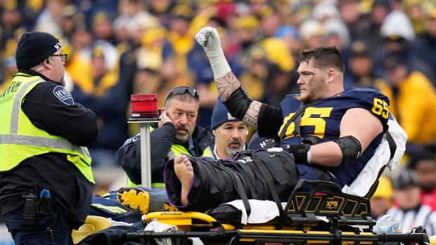 Nov 25, 2023; Ann Arbor, Michigan, USA; Michigan Wolverines offensive lineman Zak Zinter (65) is carted off by medic