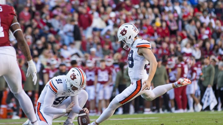 oNov 11, 2023; Fayetteville, Arkansas, USA;  Auburn Tigers place kicker Alex McPherson (38) kicks an extra point from holder Oscar Chapman (91) during the first quarter against the Arkansas Razorbacks at Donald W. Reynolds Razorback Stadium. Auburn won 48-10. Mandatory Credit: Brett Rojo-USA TODAY Sports