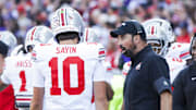 Sep 27, 2025; Seattle, Washington, USA; Ohio State Buckeyes head coach Ryan Day speaks with quarterback Julian Sayin (10) during a fourth quarter timeout against the Washington Huskies at Husky Stadium. Mandatory Credit: Joe Nicholson-Imagn Images