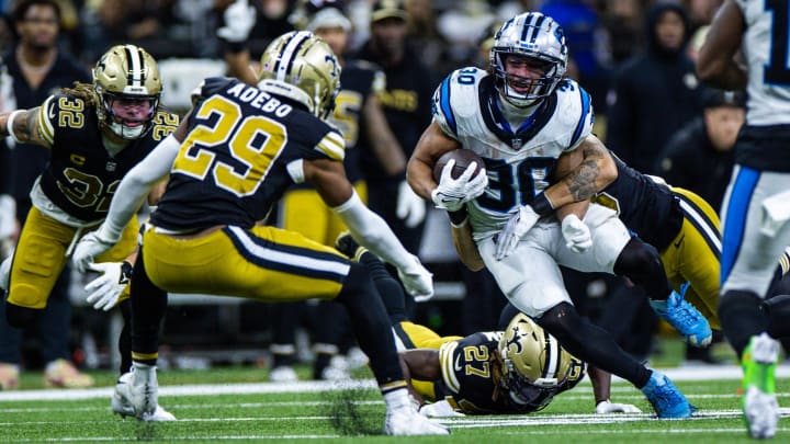 Dec 10, 2023; New Orleans, Louisiana, USA; Carolina Panthers running back Chuba Hubbard (30) rushes against New Orleans Saints cornerback Paulson Adebo (29) and safety Tyrann Mathieu (32) during the second half at the Caesars Superdome. Mandatory Credit: Stephen Lew-USA TODAY Sports