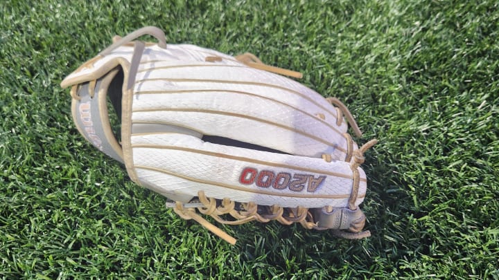 A softball glove lays on the field