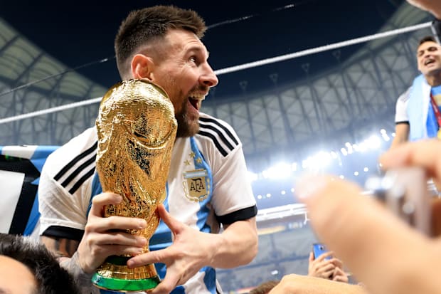 Lionel Messi hoisting the World Cup trophy